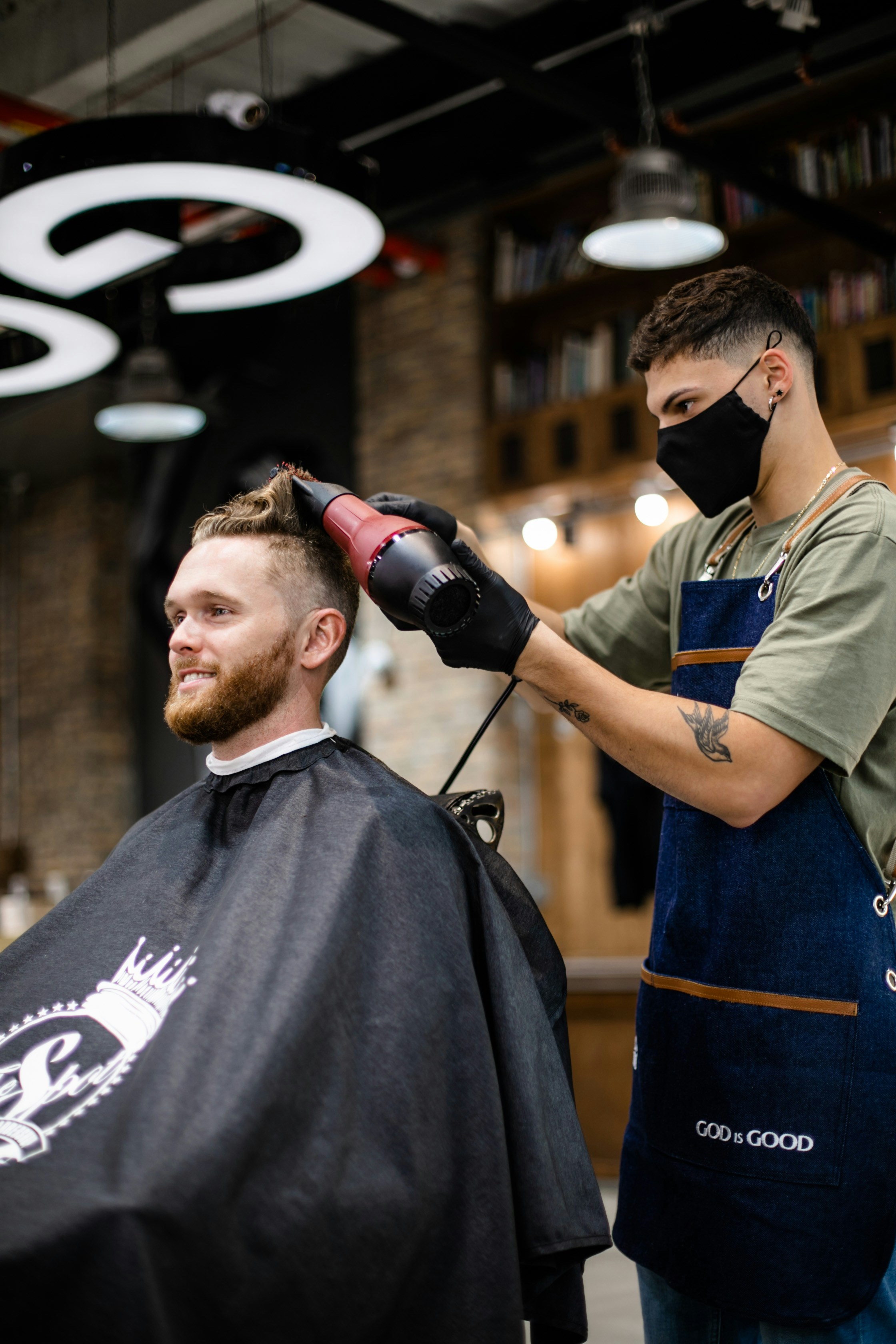 Coiffeur en train de réaliser une coupe dans son salon